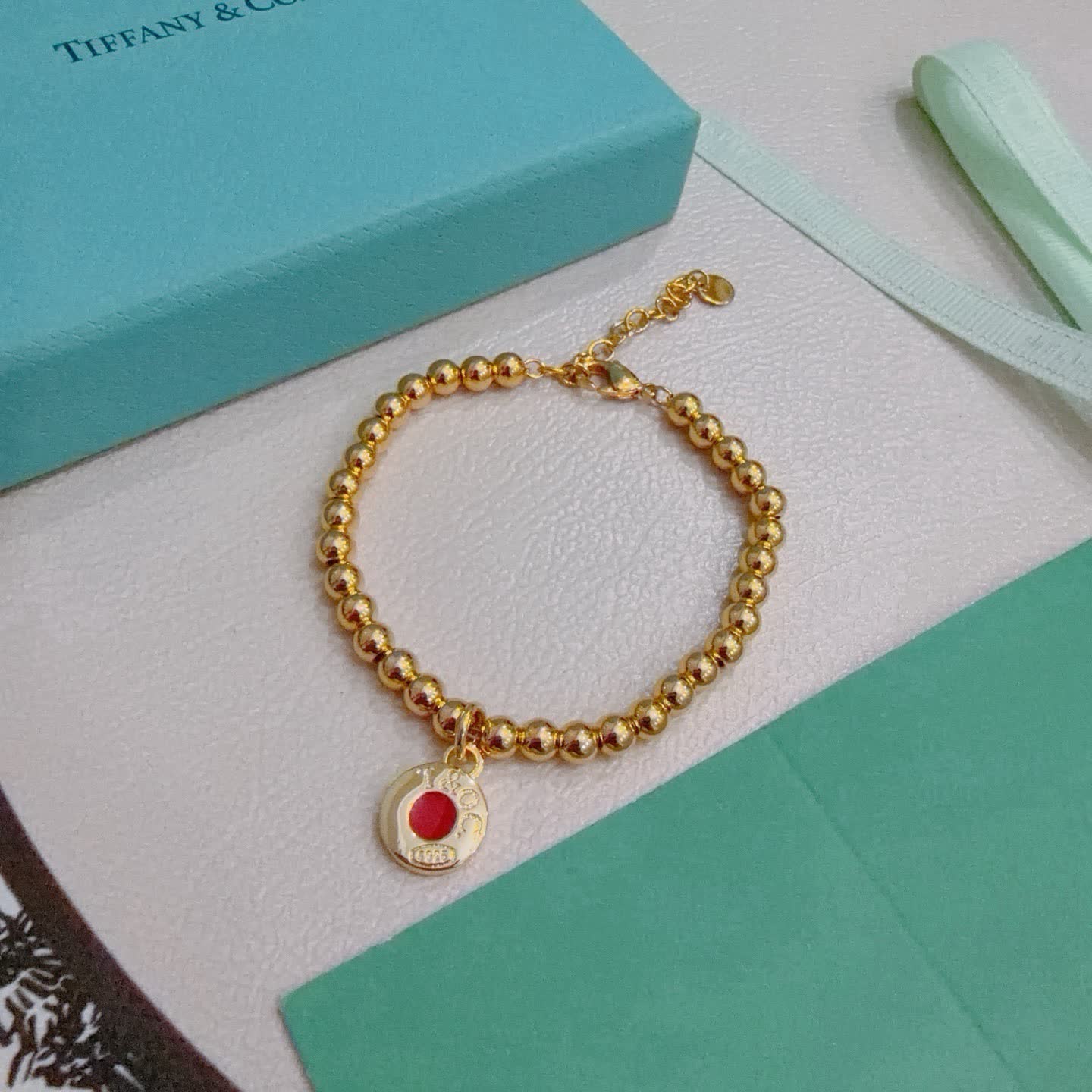 Tiffany & Co. Gold Bead Bracelet with Red Enamel Charm